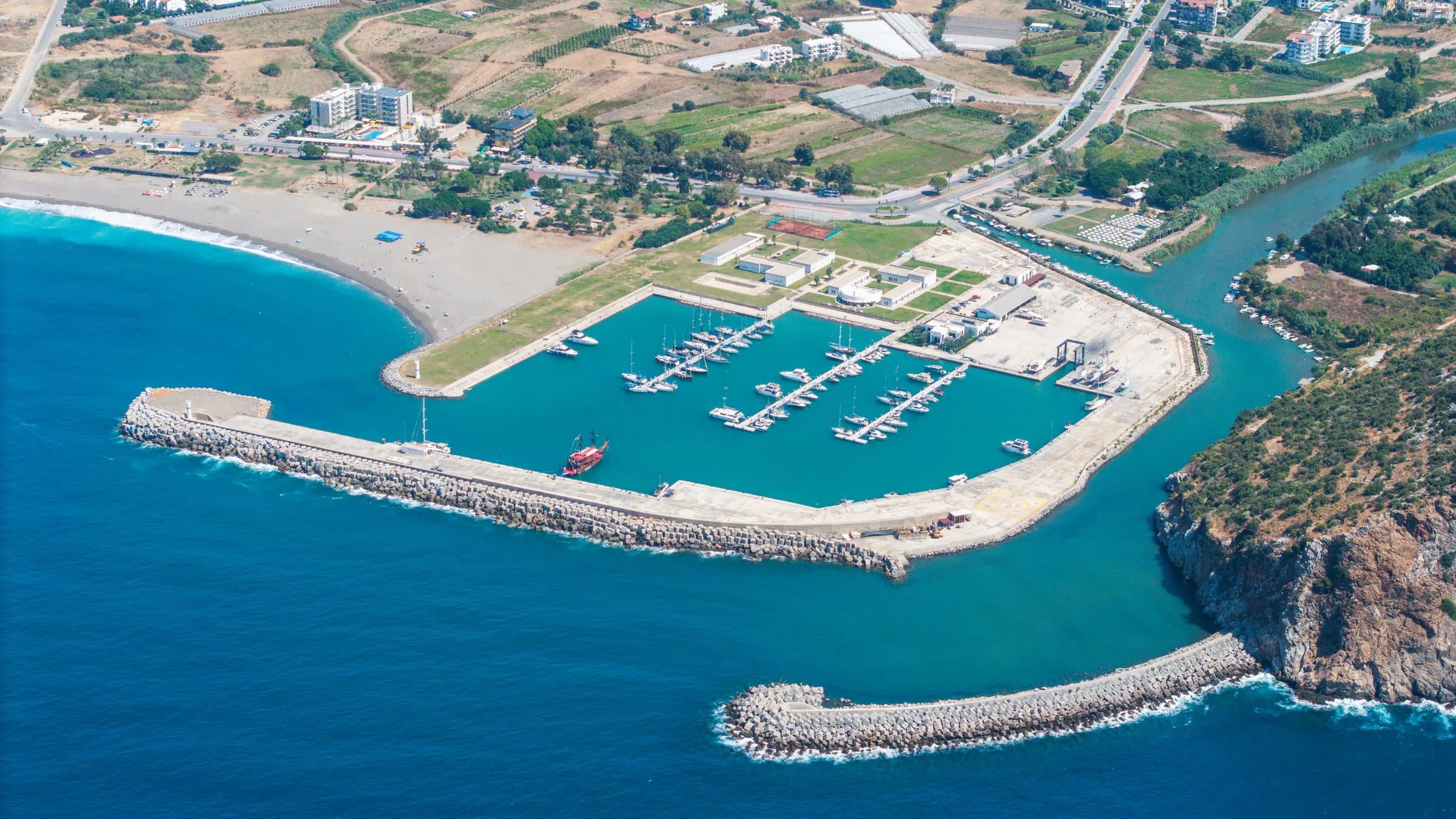Gazipaşa Gold Marina’nın mendirekleri, bağlama havuzu ve kıyı şeridiyle havadan görünümü